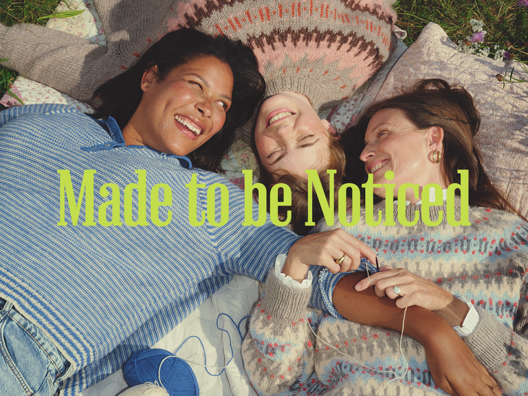 Tre kvinder ligger på et tæppe iført sweatre strikket med Copenhagen Fibers.