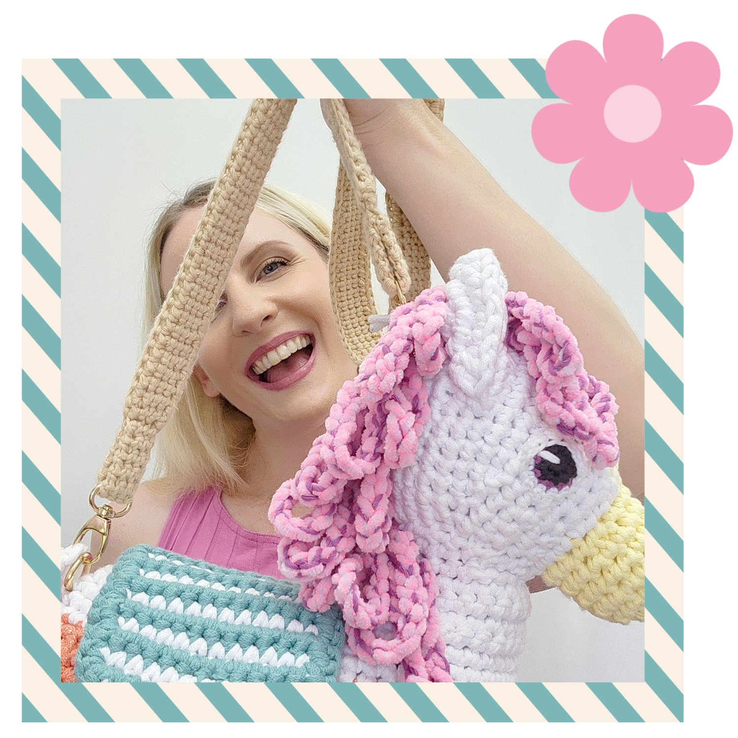 Woman, projectarian, holding a crocheted unicorn bag with a pink flower graphic on a striped background